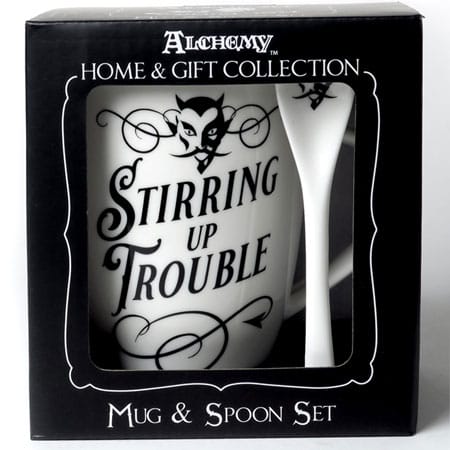Front view of the gift set that has an open faced box revealing the white mug and spoon set with black printing. The mug has cute scroll designs and a cute little devil head on the mug and matching spoon.