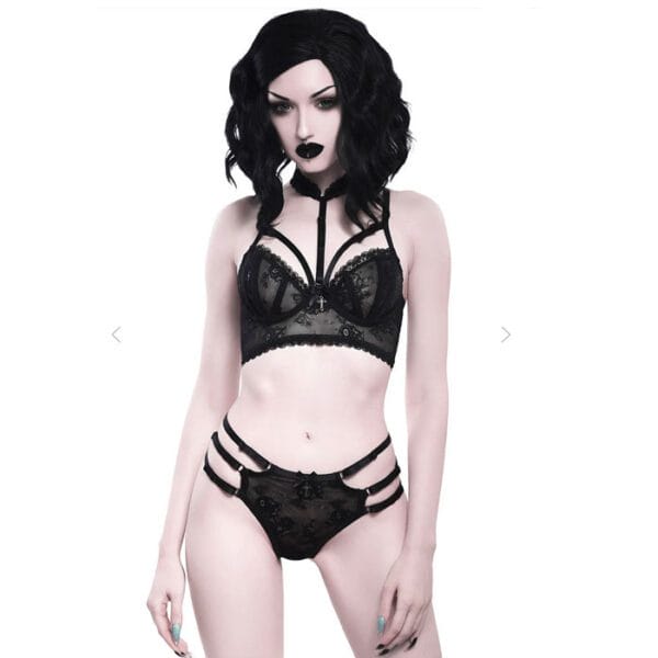 Alternative model wearing a matching bralet and panty set. Beautiful delicate black lace patterning with strappy features. Bra finishes at the neck with a delicate choker.