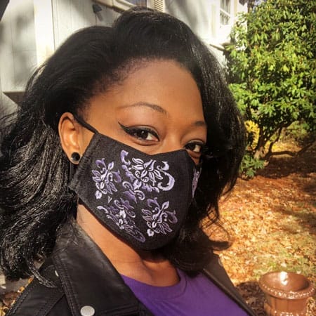 Yani from Massachusetts modeling the Vampfangs black cotton face mask. This style is embroidered with a purple brocade pattern. It is beautiful and comfortable.