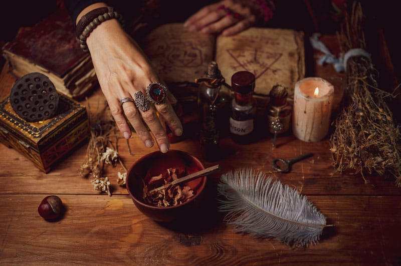 A woman crafting a candle with magical ingredients.